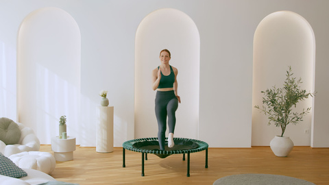 Eine Frau trainiert auf dem bellicon mit Mint Seilringen.